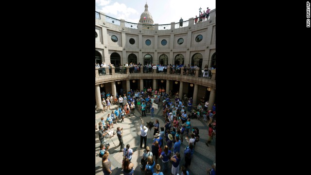 A man blows a horn as supporters and opponents of an abortion bill gather near a hearing for the bill at the state Capitol on July 2.