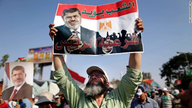 A supporter of Morsy holds a poster that reads, "The people support legitimacy for the president," during a rally in Cairo on July 3.
