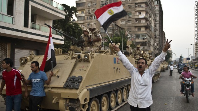 Egyptians salute Army tanks upon their deployment on a street leading to Cairo University on July 3.