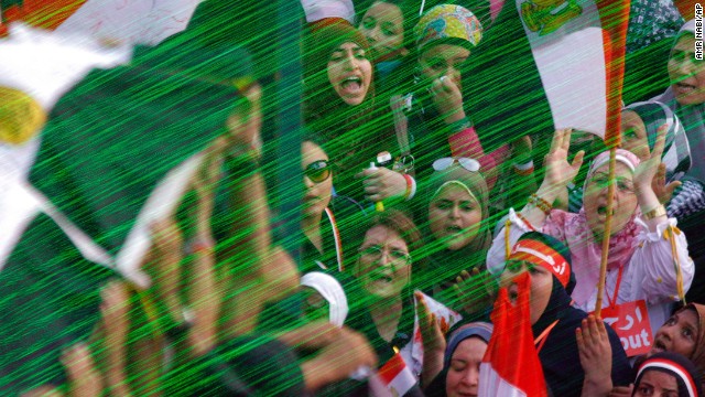 On July 3 in front of a symbolic coffin, green lasers illuminate opposition protesters performing funeral prayers for Egyptians killed during clashes between supporters and opponents of Morsy.