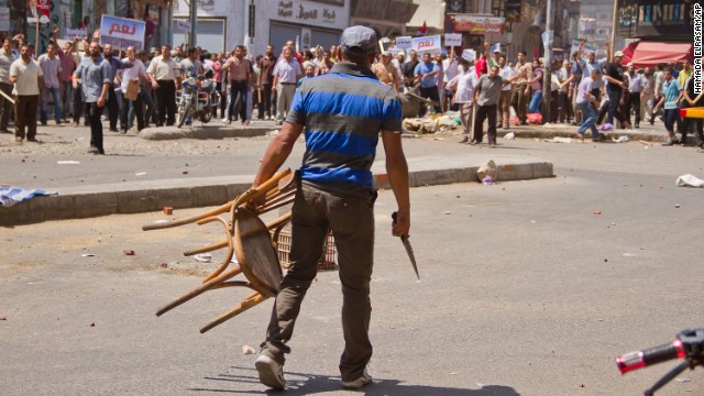 An opposition protester holds a chair and knife during clashes between supporters and opponents of Morsy on July 3 in downtown Damietta, Egypt, which is north of Cairo near the Mediterranean Sea.