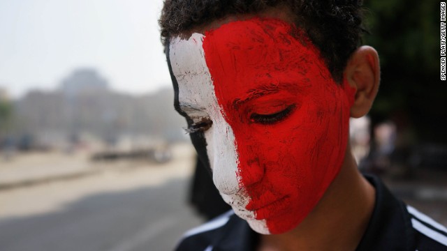 A boy with face paint the color of the Egyptian flag pauses on July 4 in Tahrir Square.