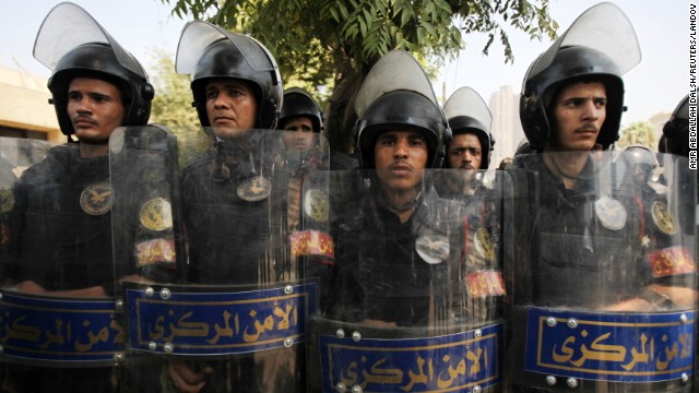 Riot police stand guard as members of the Muslim Brotherhood and supporters of Morsy protest in front of Egypt's Constitutional Court in Cairo on July 4.