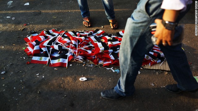 People walk by a pile of Egyptian flags for sale in Tahrir Square on July 4.