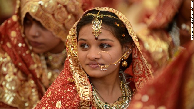 An Indian Muslim bride gestures during a mass wedding ceremony at the ancient Sarkhej Roja in Ahmedabad on February 22, 2013. Some 151 couples participated in a mass marriage organised by Hussaini Waqaf Committee. Participation in mass marriages in the Muslim and Hindu communities are on the rise against the 'Dowry System' in which huge donations are paid by the bride's family members to the family members of the grooms. Instead, in the mass marriages the brides are gifted with the basic necesitities of daily life. 