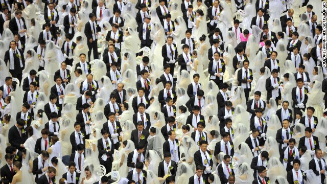 Rows of newly-wedded brides and grooms stand and mingle at the Unification Church's mass wedding held at its headquarters in Gapyeong, east of Seoul, on February 17, 2013, that saw some 3,500 couples matched by the church tie the knot. The Unification Church, set up by Sun Myung Moon in Seoul in 1954, is one of the world's most controversial religious organisations, and its devotees are often dubbed "Moonies" after the founder