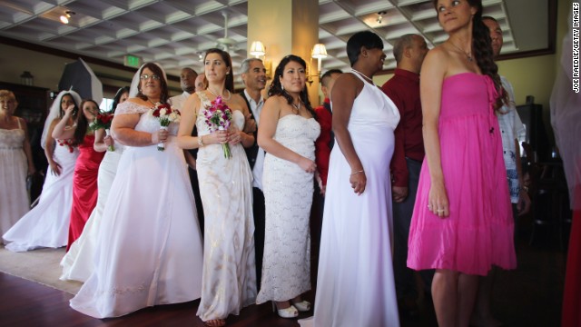 Brides line up with their husbands to be during a group Valentine's day wedding at the National Croquet Center on February 14, 2013 in West Palm Beach, Florida. The group wedding ceremony is put on by the Palm Beach Country Clerk &amp; Comptroller's office and approximately 40 couples tied the knot. 