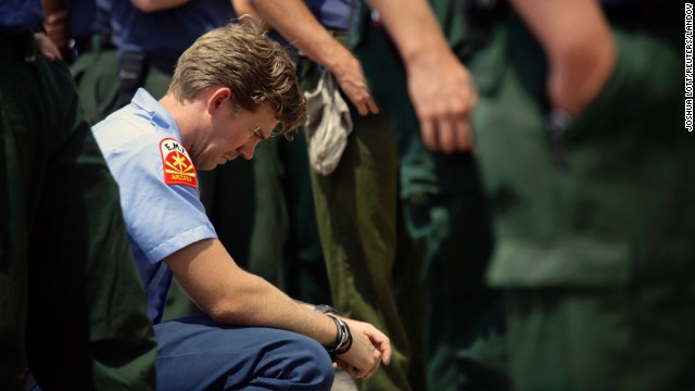 Firefighter Sean Kauffman pays his respects at a makeshift memorial outside the Granite Mountain Interagency Hotshot Crew fire station in Prescott, Arizona, on Thursday, July 4. Kauffman is a former member of the elite firefighting crew.