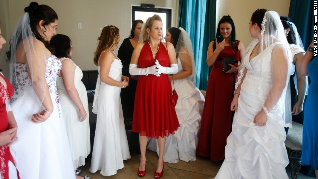 A dozen brides wait to be married during a ceremony for a radio station contest at the Little Chapel of the Flowers on December 12, 2012 in Las Vegas, Nevada. Couples around the world are hoping that a once-in-a-lifetime event, the date 12/12/12, will bring added luck to their marriages.