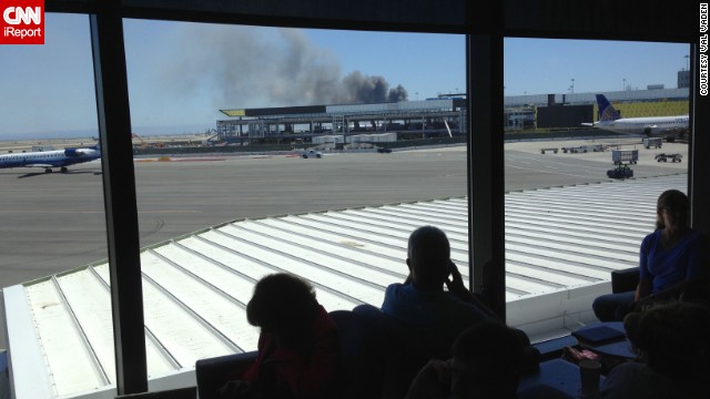 iReporter Val captured this photo while waiting in a departure lounge at the San Francisco airport on July 6. Val observed the billowing smoke and emergency responders' rush in. 