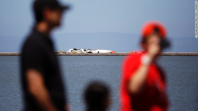 People look over the wreckage across a cove in San Francisco Bay on July 6.