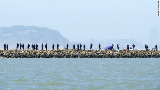 Crews comb the end of a San Francisco airport runway following the crash landing on July 6.