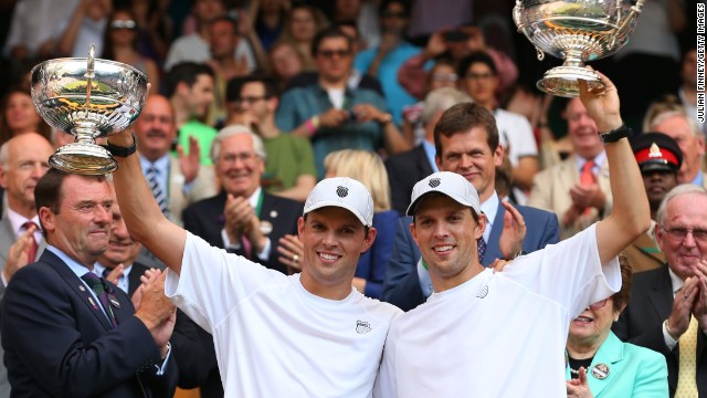 Mike Bryan and Bob Bryan pose with their trophies after winning the men's doubles title at Wimbledon. 