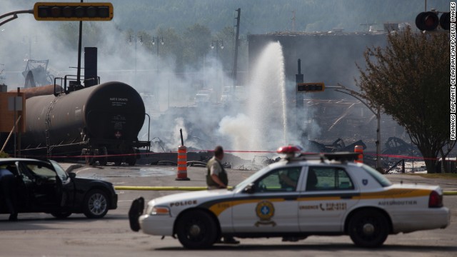 Firefighters continue to douse burning wreckage on July 7 in Lac-Megantic, Quebec.