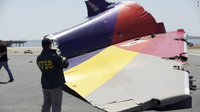 An investigator inspects the broken-off tail of the plane in a handout photo released July 7. The crash killed two people, injured 182 and forced the temporary closure of one of the country's largest airports.