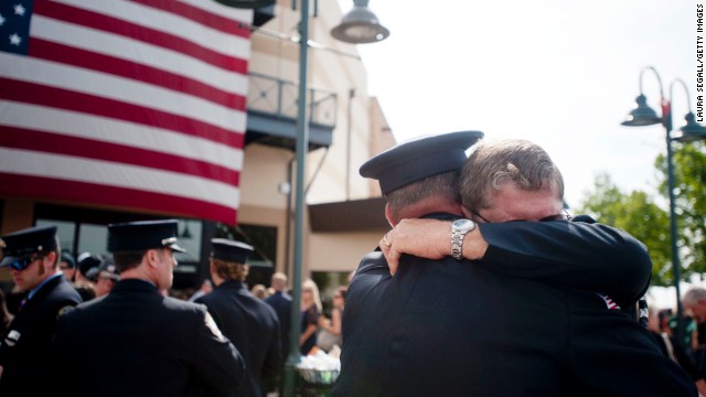 Chaplain Bob Ossler, right, hugs people at a Prescott Valley, Arizona, memorial service on Tuesday, July 9, honoring the fallen firefighters of the Yarnell Hill Fire. <a href='http://www.cnn.com/interactive/2013/07/us/yarnell-fire/index.html'>Nineteen members of the Granite Mountain Hotshots</a> died Sunday, June 30, battling the wildfire. 