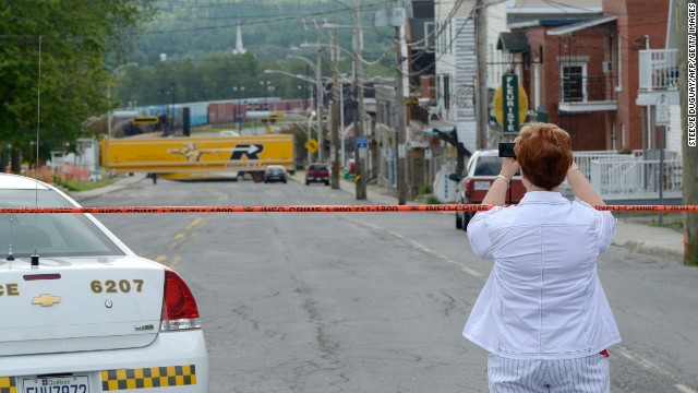 A woman takes a photo of the devastation on Tuesday, July 9.
