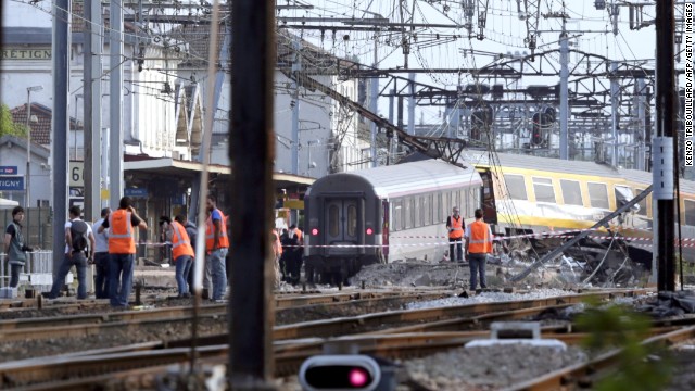 Rescuers work on the site of a train accident in the railway station of Bretigny-sur-Orge, on Friday, July 12 near Paris. The train was passing through the station but was not scheduled to stop there, according to Guillaume Pepy, president of the French national railway company, SNCF.