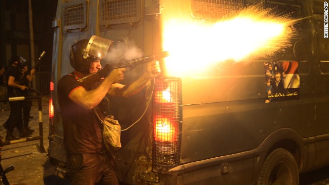 A riot police officer fires tear gas toward Morsy supporters during clashes in Cairo on Monday, July 15.