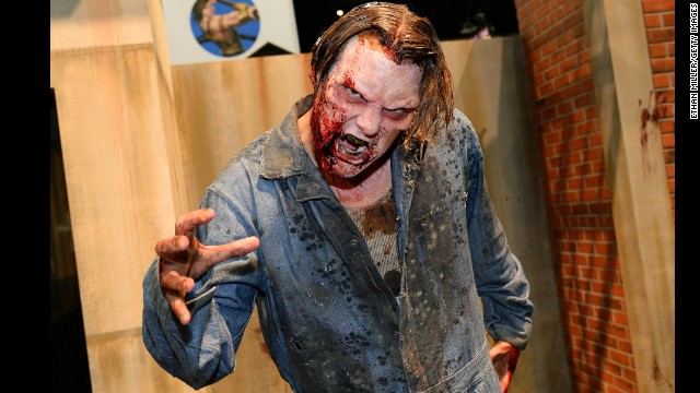 A zombie character poses at "The Walking Dead" booth.