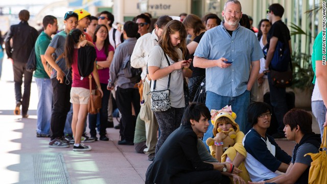 People wait in line outside the convention center hoping to get a volunteer pass.