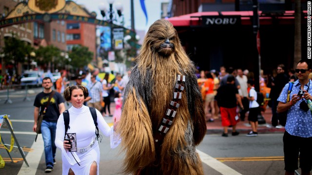 Fans dressed as "Star Wars" characters Princess Leia and Chewbacca walk down San Diego's 5th Avenue.