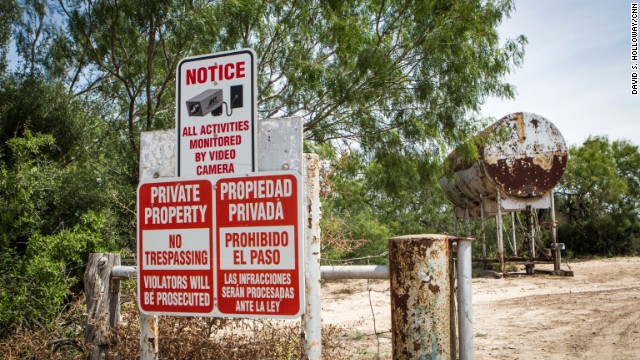 A sign warns of security cameras on a farm near the border. 