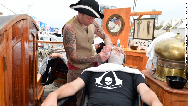 Barbers dressed as pirates shave customers at the Assassin's Creed IV Black Flag Jackdaw Ship on July 20.