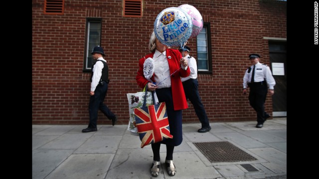 Royal supporter Margaret Tyler holds decorative balloons as she waits outside St. Mary's Hospital in London on Saturday, July 20.