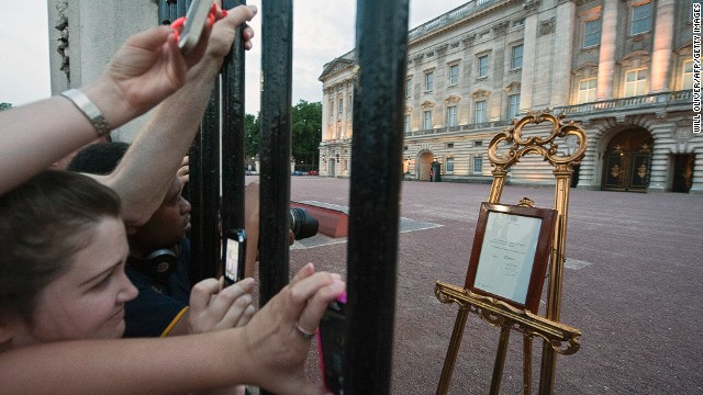 People clamor for their chance to see and photograph the birth announcement that was placed on a golden easel by the queen's press secretary on July 22.