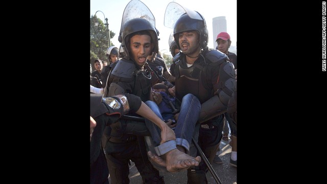 Riot police evacuate an injured anti-Morsy protester in Cairo on July 22.