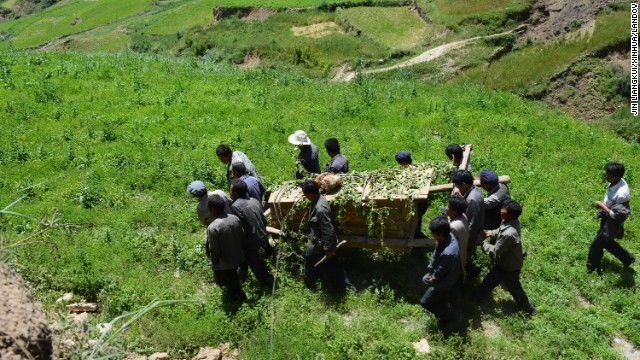 People carry a coffin July 23 during a funeral for an 84-year-old villager from Lalu who was killed in the earthquake. The death toll has risen to 94, local authorities said Tuesday. 