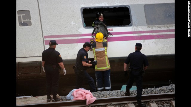 Rescue workers inspect a carriage in the wreckage July 25.