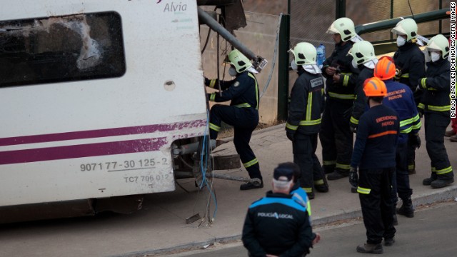 Emergency personnel work at the crash scene July 25. An investigation into the cause of the derailment is under way, but Spain's transportation minister says the train appears to have been going too fast.