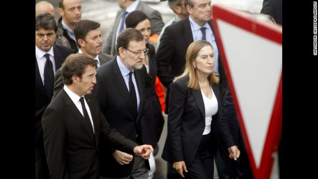 Spanish Prime Minister Mariano Rajoy, center, visits the crash site July 25 with Public Works Minister Ana Pastor, right, and Alberto Nunez Feijoo, head of the regional government in Galicia. The latter declared seven days of mourning for victims of the crash.<!-- --> </br>