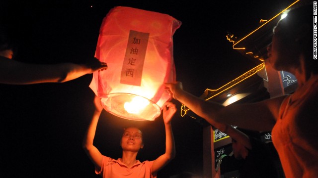 People pray for the earthquake victims in Laibin, China, on July 24. 