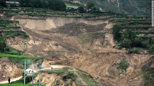 People look at damage on July 24 from a landslide triggered by Monday's earthquake.