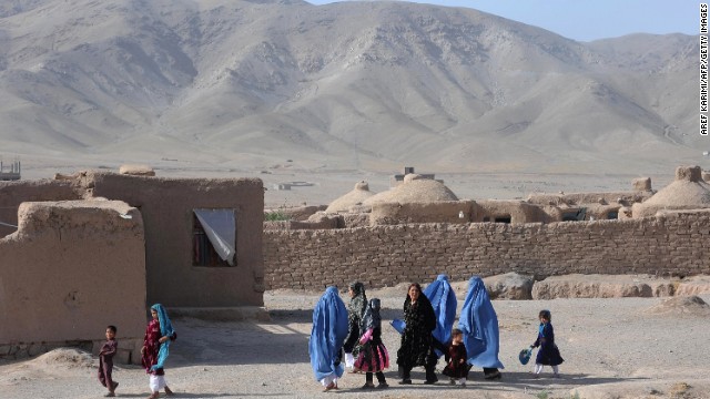 Afghan women, with their children, walk on the outskirts of Herat on June 11, 2013. 