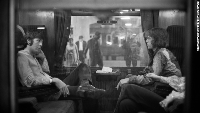 Paul McCartney of the Beatles, left, sits across from Jagger on a train at London's Euston Station in 1967.