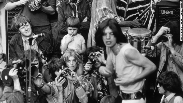 Jagger performs with the Rolling Stones in central London's Hyde Park in 1969. His then-girlfriend Marianne Faithfull watches from behind the photographers.