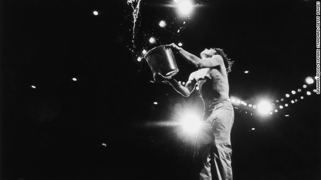 Mick Jagger empties a bucket of water on stage at the 1976 Knebworth Festival in Hertfordshire, England.