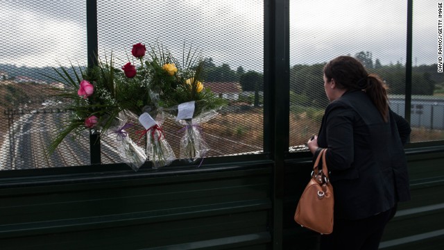 A woman looks on from a bridge where flowers were displayed in memory of the victims on July 26. The crash occurred on the eve of a public holiday, when more people than usual may have been traveling in the region. 