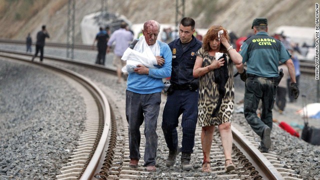 Injured people are evacuated at the site of the July 24 train accident. The driver of the train is under detention and is being investigated for a "crime," Spanish police said on July 26. 