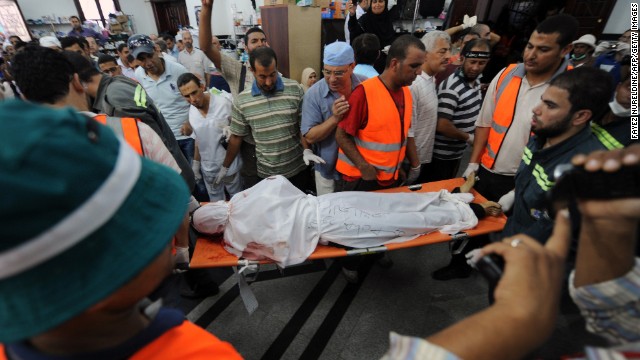 The body of a Muslim Brotherhood protester, reportedly shot dead after violence erupted the night before, is moved as mourners watch inside a field hospital in Cairo on July 27.