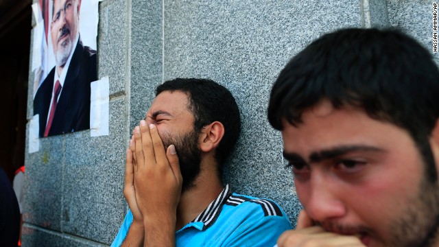 Two men mourn Morsy supporters who were killed in overnight clashes with security forces, in Cairo, on July 27.