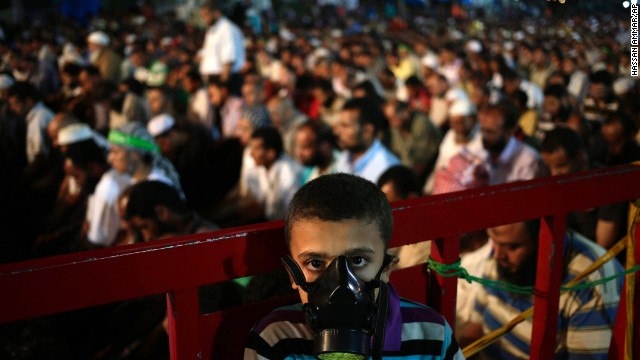 A boy wears a tear gas mask as supporters of Egypt's ousted President Mohammed Morsy pray at the camp set up by supporters in the Nasr City area of Cairo on July 28. 