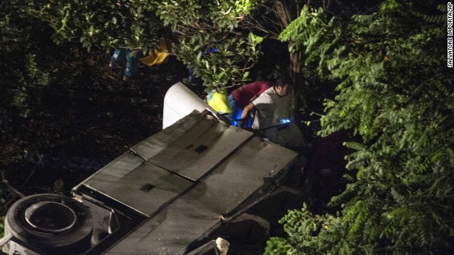 Rescuers clamor over the overturned bus as they try to free passengers. 