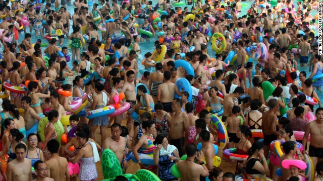 Mass crowds of people attempt to cool off at a water park in Suining, Sichuan province on Saturday, July 27, amid a record heat wave hitting 19 provinces and regions in China. 