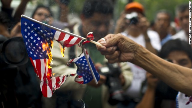 A woman burns American flags during a protest in support of Bolivian President Evo Morales in front of the U.S. embassy in Mexico City on July 4. Leftist Latin American leaders and activists were fuming after some European nations temporarily refused Morales' plane access to their airspace amid suspicions Snowden was aboard.