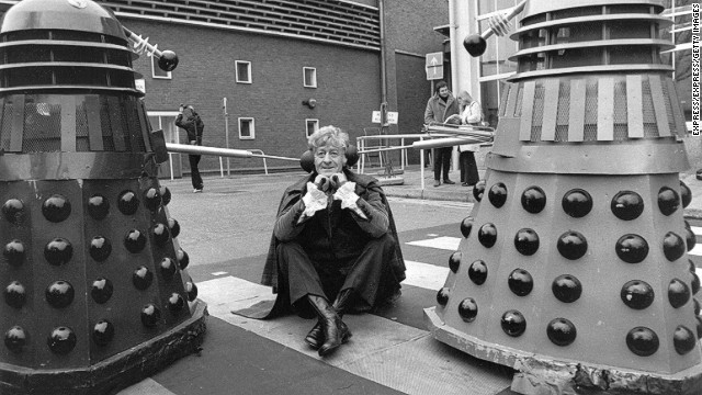 The third Doctor, played by Jon Pertwee from 1970-1974, sits in the car park of BBC Television Centre, London, guarded by two Daleks in 1972.